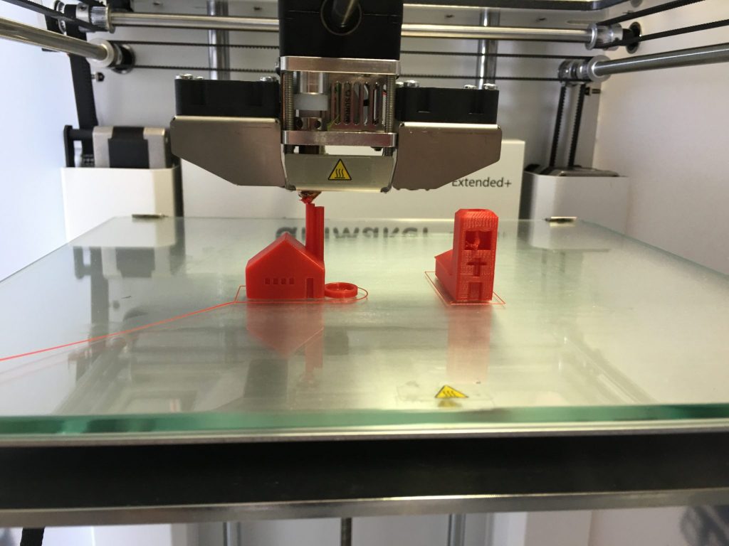 3d-printing-little-red-figures-for-a-gift A 3D Printer printing out miniature D&D figurines